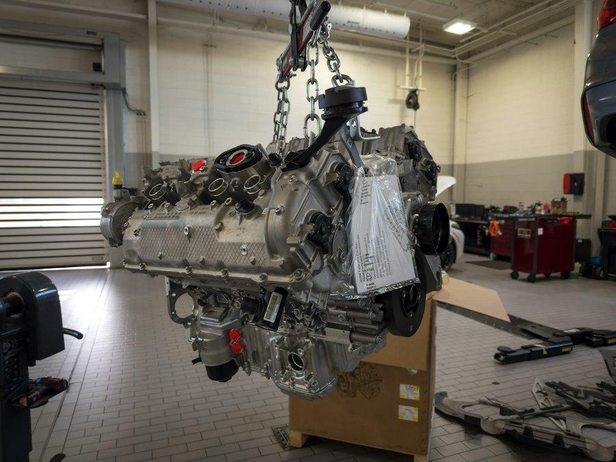 Moteur de remplacement suspendu à la grue d'atelier, prêt à être posé